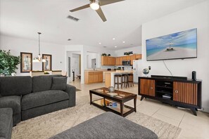 A modern living room with a sofa, coffee table, and TV stand. - Last Minute Disney Getaway! Private Pool & Comfortable Bedrooms. Book Now! #167221 (Orlando)