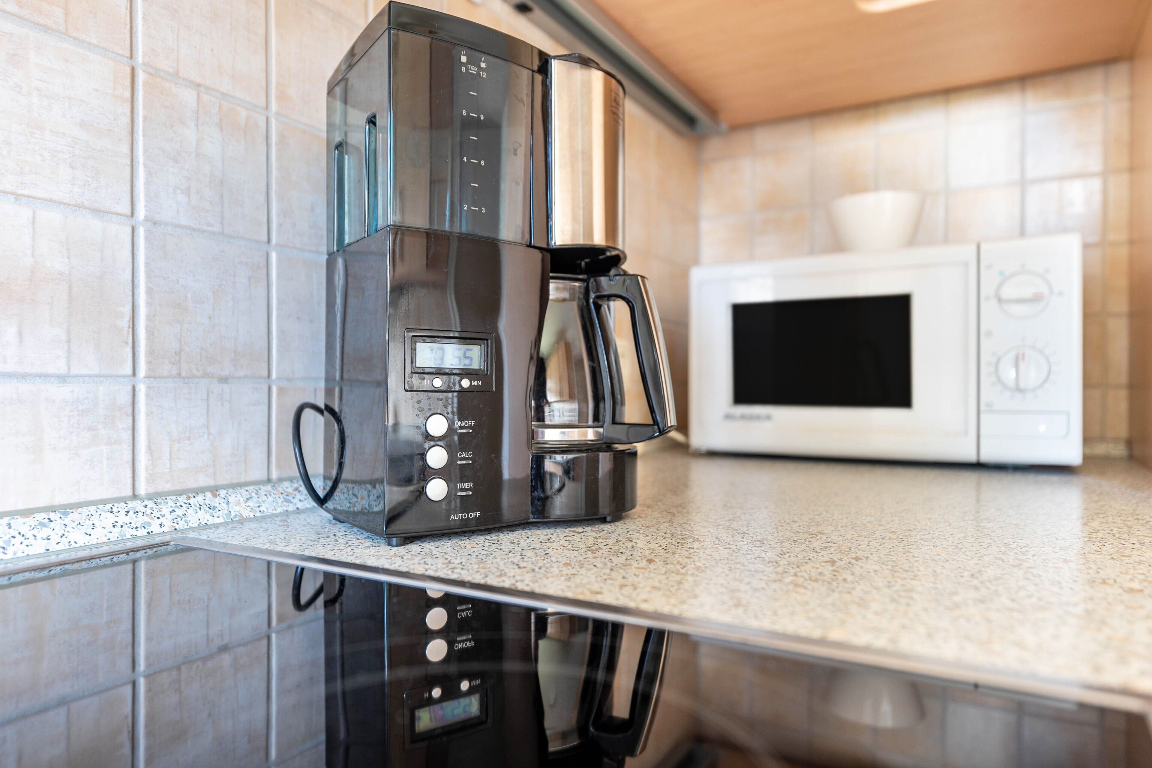 Eine Küche mit Kaffeemaschine und Mikrowelle auf einer Arbeitsplatte.