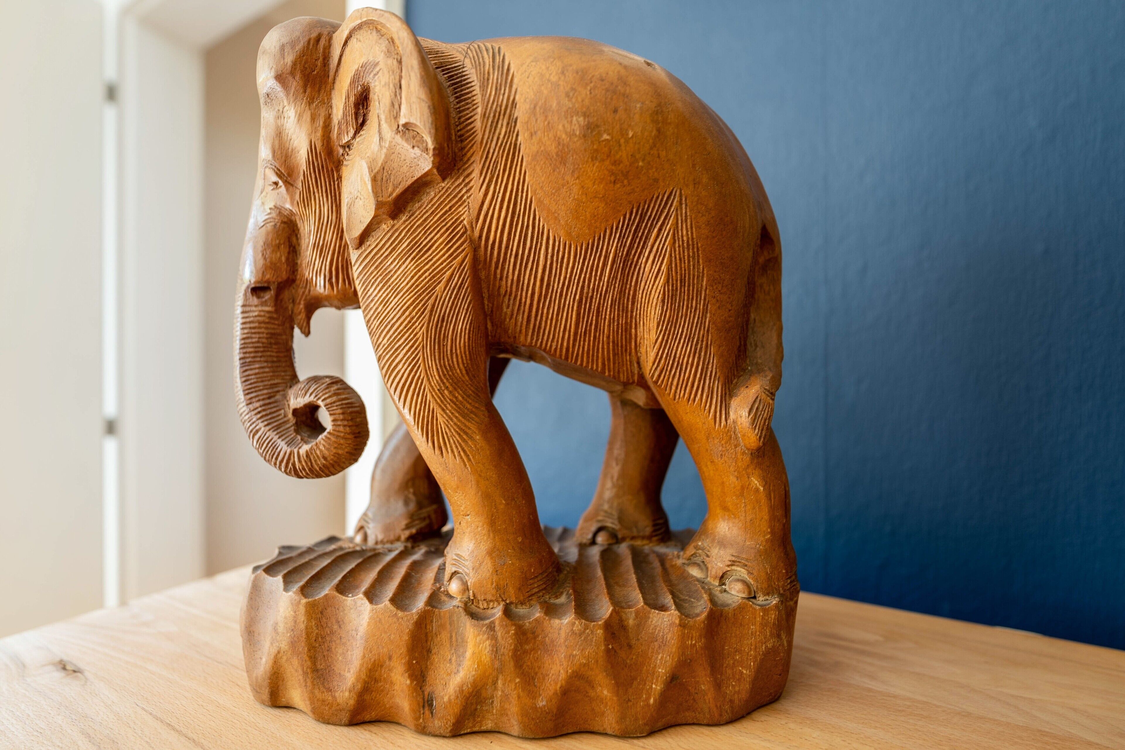 Une sculpture d’éléphant en bois, posée sur une table.