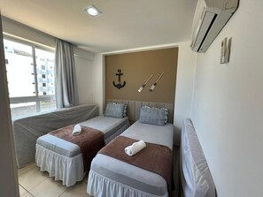 Ein Hotelzimmer mit zwei Betten, einem Vorhangfenster, einer Klimaanlage und einer Wanddekoration.