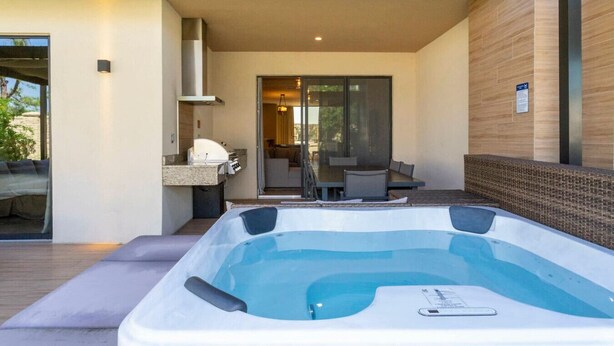 Ein Whirlpool auf einer Terrasse mit Blick auf einen Essbereich und eine Küche.