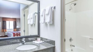 A hotel bathroom with a sink, mirror, and shower. - Super 8 by Wyndham Clovis (Clovis)