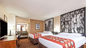 A hotel room with two beds, a desk, a TV, and a large abstract painting on the wall. - Super 8 by Wyndham Clovis (Clovis)