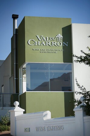 Un bâtiment sur lequel on peut lire l’inscription suivante : « Vau Puu Charron, domaine viticole et oliveraie, espace gastronomique ».