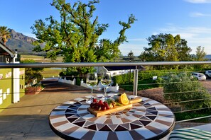 A dining table with a view of a vineyard and mountains. - Val du Charron Wine and Leisure Estate Guesthouse (Wellington)