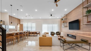 A modern living room with a TV, sofa, and dining area. - Last Minute Disney Getaway! Private Pool, Game Room & Themed Bedrooms. Book Now! #172545 (Orlando)