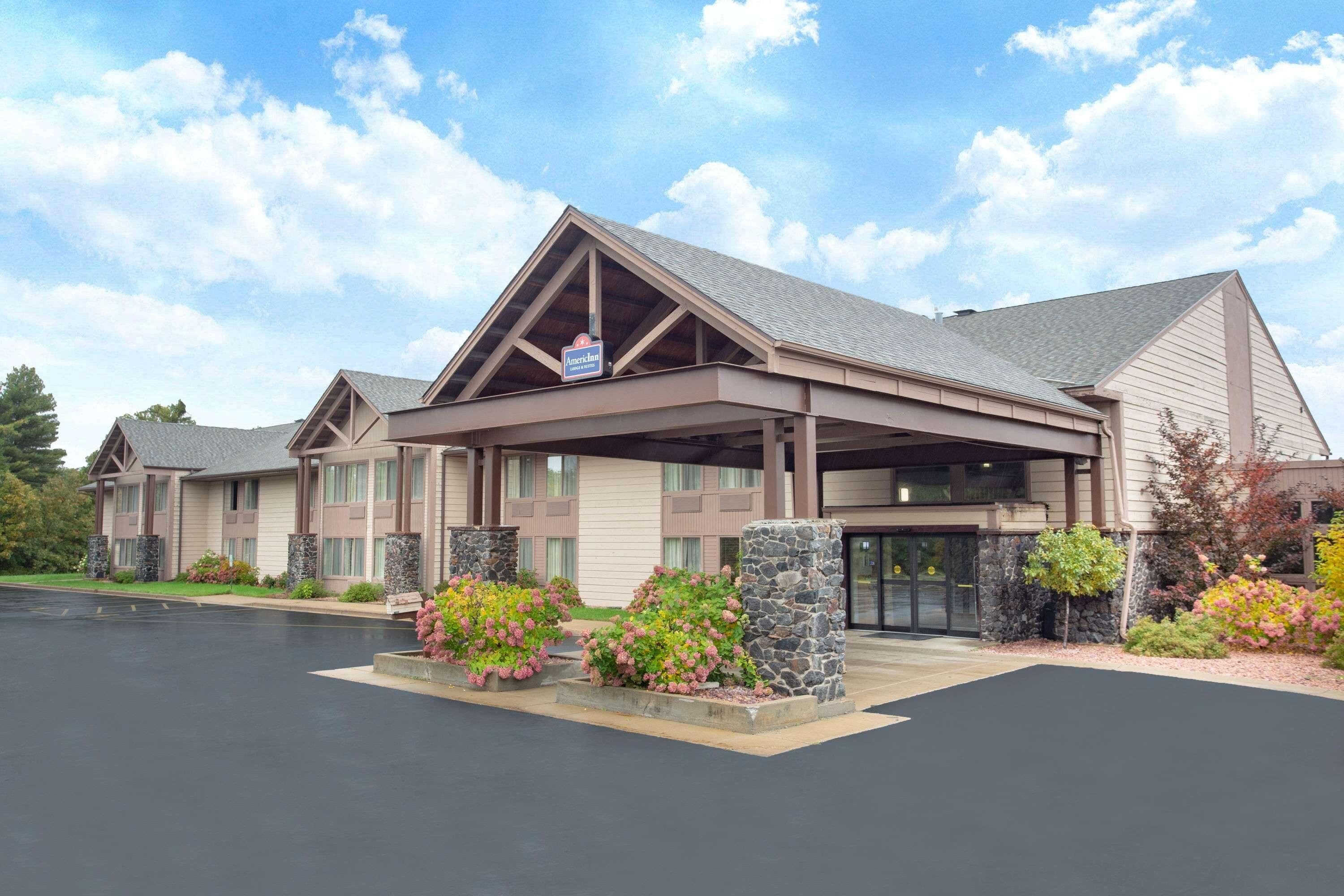 A hotel with a covered entrance, multiple windows, and stone pillars.