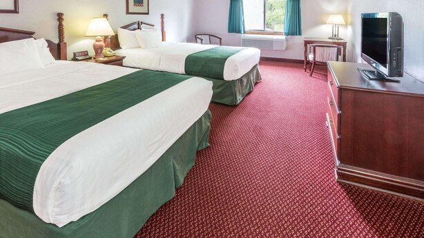 A hotel room with two beds, a television, a desk, and a chair. - Days Inn by Wyndham Tiffin (Tiffin)