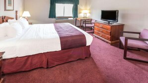 A hotel room with a large bed, a desk, a television, and a chair. - Days Inn by Wyndham Tiffin (Tiffin)