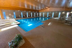 An indoor swimming pool with a wooden ceiling, tiled walls, and sunlit windows. - Ramada Conference Center By Wyndham Lewiston (Lewiston)