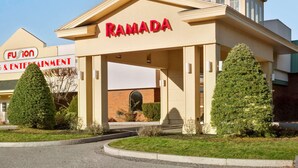 Een gebouw met een bord waarop 'RAMADA' staat en een ander bord voor 'Fusion Entertainment & Entertainment'.