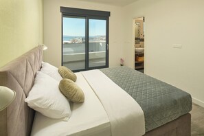 A bedroom with a bed, a window with a view, and a door leading to a bathroom. - Luxury villa Natali with pool (Podstrana)
