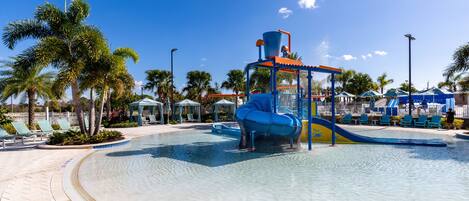 A water park with a large pool, slides, and palm trees.