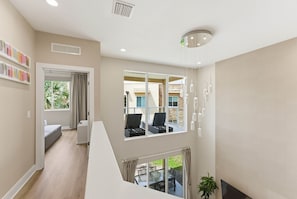 A modern interior with a staircase, a balcony with outdoor furniture, and a large window offering a view of the outside. - Last Minute Disney Getaway! Comfortable Bedrooms & Private Terrace. Book Now! #173053 (Orlando)