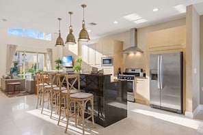 A modern kitchen with a central island, stainless steel appliances, and pendant lighting. - Last Minute Disney Getaway! Comfortable Bedrooms & Private Terrace. Book Now! #173053 (Orlando)