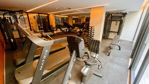 Ein Fitnessstudio mit Laufbändern, Kraftgeräten und Trainingsausrüstung.