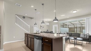 A spacious kitchen with a central island, built-in dishwasher, and pendant lighting. - Last Minute Disney Getaway! Private Pool & Themed Bedrooms. Book Now! #173071 (Orlando)