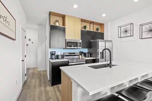 A modern kitchen with a central island, built-in appliances, and a minimalist design. - Last Minute Disney Getaway! Bright and Modern Townhouse with Terrace. Book Now! #172835 (Orlando)