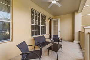 An outdoor seating area with a ceiling fan, a bench, and two chairs. - Prime location·Mins from Epic Universe & I-Drive (Orlando)