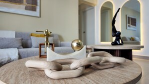 Ein runder Holztisch mit einer verzierten Metallskulptur und einer kugelförmigen Figur.