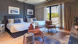A modern hotel room with a large bed, a seating area, and a view of the outdoors. - Loft Elegance 2 bed | Gym • Pet Friendly • AC (Guadalajara)