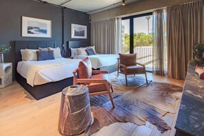 A modern hotel room with a large bed, a seating area, and a view of the outdoors. - Loft Elegance 2 bed | Gym • Pet Friendly • AC (Guadalajara)