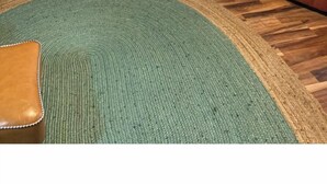 Una sala de estar con un sofá, una mesa de comedor con sillas, una zona de cocina con ventanal y un reloj en la pared.