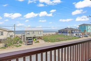 A coastal residential area with houses, a beach, and a clear sky.