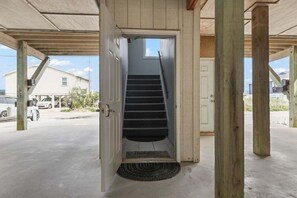 Eine Treppe führt zu einer oberen Ebene, mit einer Tür unten und einem Fenster darüber.