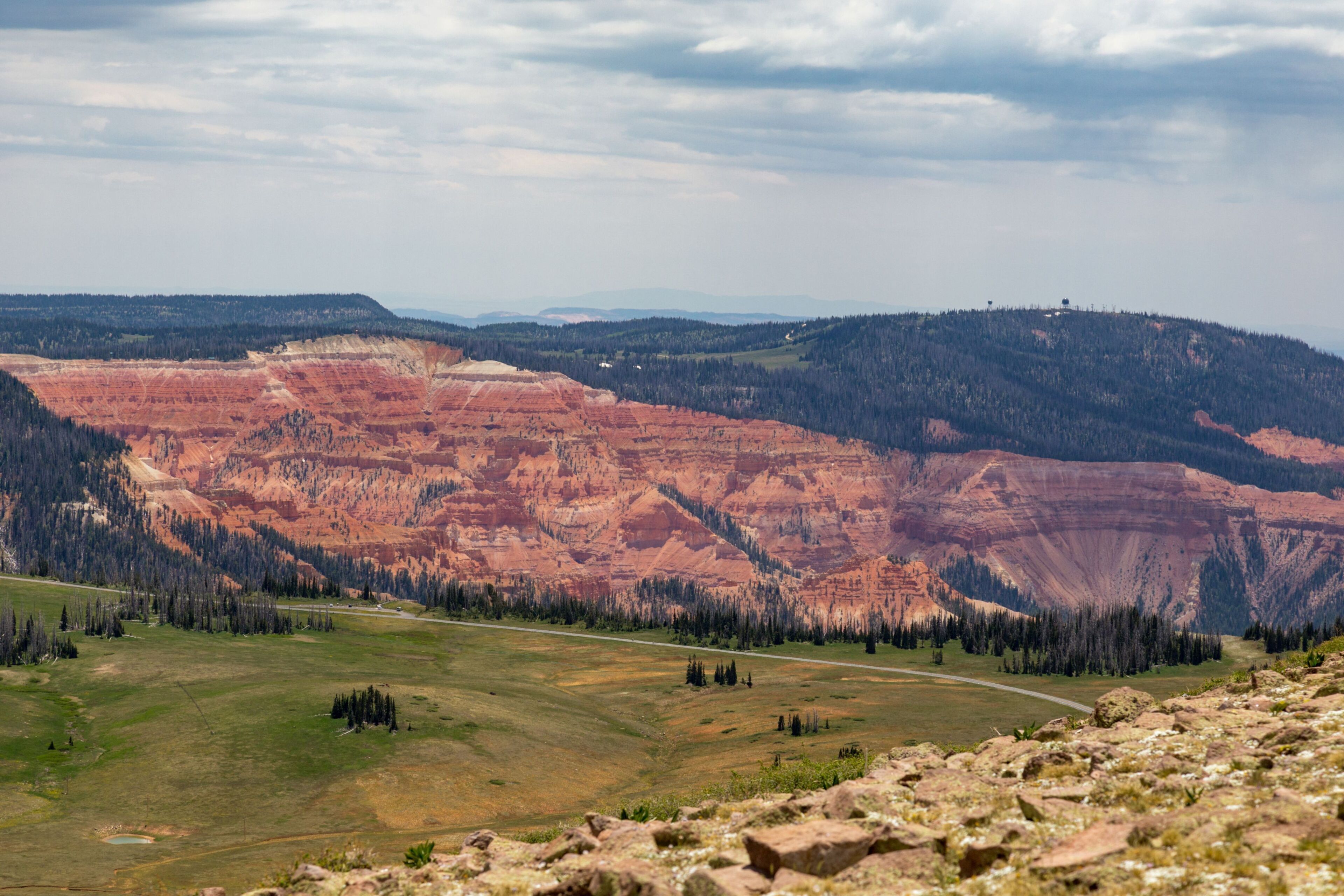 Une vue panoramique d’un paysage montagneux, avec une route qui traverse une vallée.