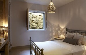 A bedroom with a bed, bedside lamp, window, and a hanging light fixture. - Villa Mirethiax, Divine Sea Views, Furnished Terrace, Tinos (Tinos)