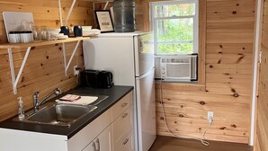 A compact kitchen with a sink, countertop, and a window. - Cozy Retreat For Two (Greater Sudbury)