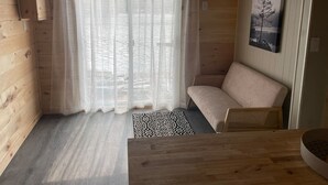 Un interior de fusta amb un sofà, una taula i una catifes amb dibuixos.