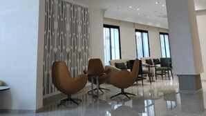 A modern interior with a high ceiling, multiple hanging lamps, and contemporary furniture.