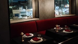 A restaurant interior with booths, tables, and hanging lamps.