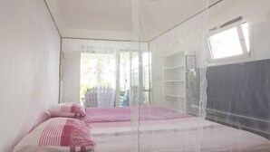 Un dormitorio con cama, ventana y balcón.