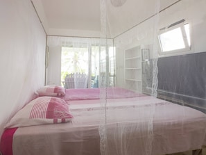 A bedroom with a bed, a window, and a balcony. - Les pieds dans l'eau avec vue sur mer (Le Moule)
