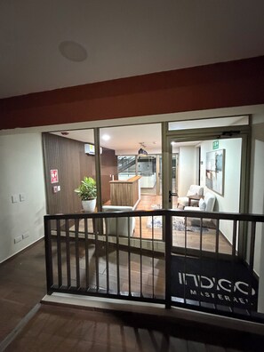 Ein Hotelinnenraum mit Treppe, einer Rezeption und einer Sitzecke.