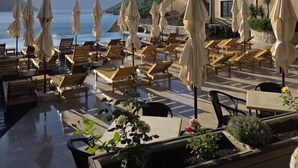 A terrace with lounge chairs and umbrellas, overlooking a body of water and mountains. - Bellezza Residence & Spa Kotor (Kotor)
