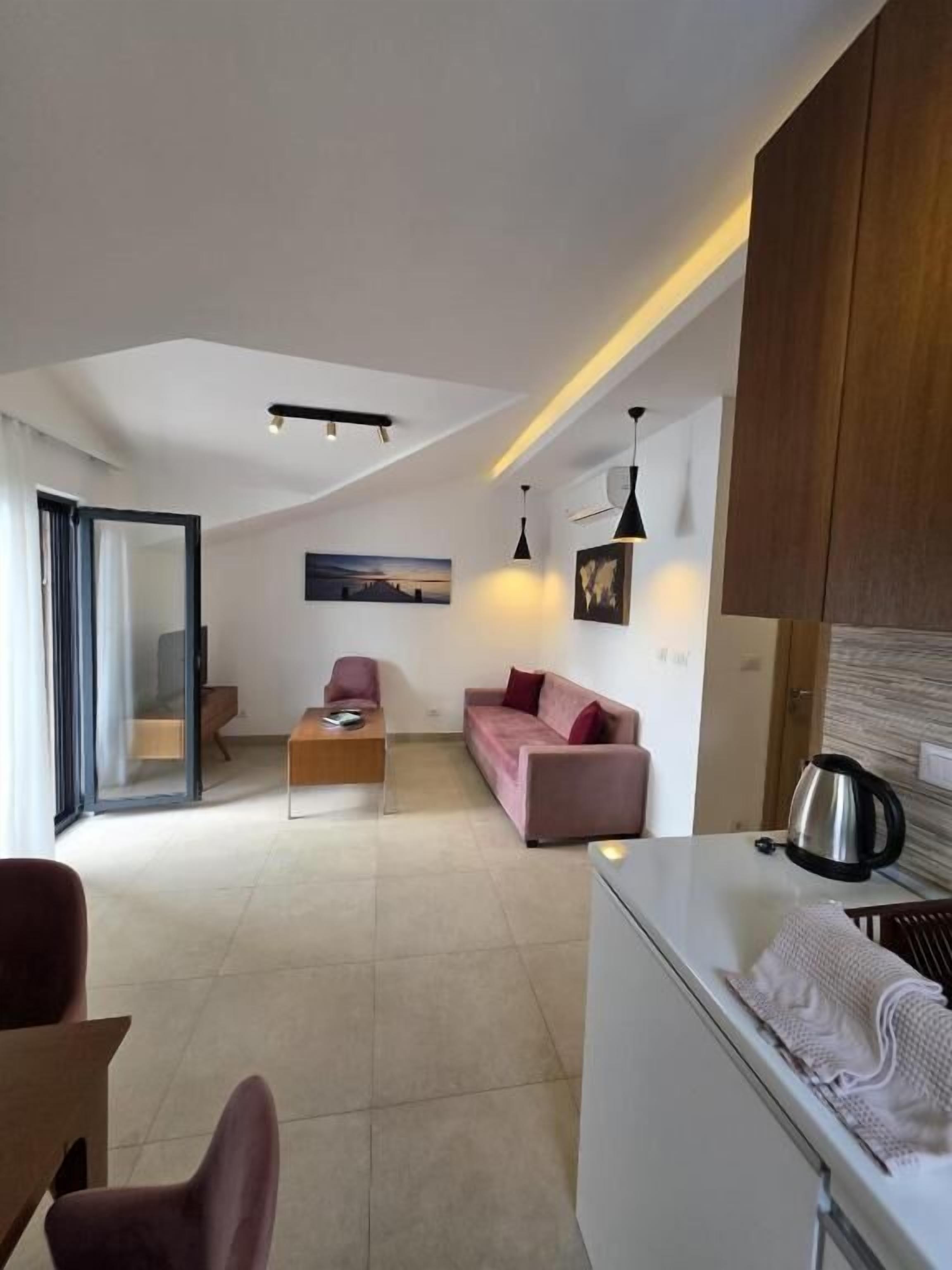 Un appartamento moderno con soggiorno, cucina e una porta vetrata che dà su un balcone.