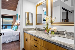 A hotel room with a bed, two sinks, wooden cabinets, and large mirrors. - Sands of Kahana 2 Oceanfront Villas, Sleeps 16 | Car Incl. w/ 6 nights | ML-4052 by KBM (Lahaina)