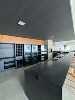 Una cocina moderna con una isla central, refrigeradores integrados y una pared decorativa de madera.