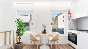 A compact kitchen with a dining area, a potted plant, and a view of the street. - GuestReady - Charming stay in Porto (Porto)
