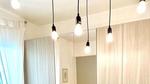A bedroom with a bed, a bedside table, a mirror, and a wardrobe. - La terrazza sul blu - Marina di Ragusa (Marina di Ragusa)