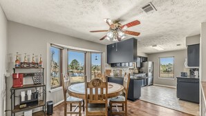 A modern kitchen with a central island, built-in appliances, and large windows offering a view of the outdoors. - Hoofs and Horns Private Ranch (Huntsville)