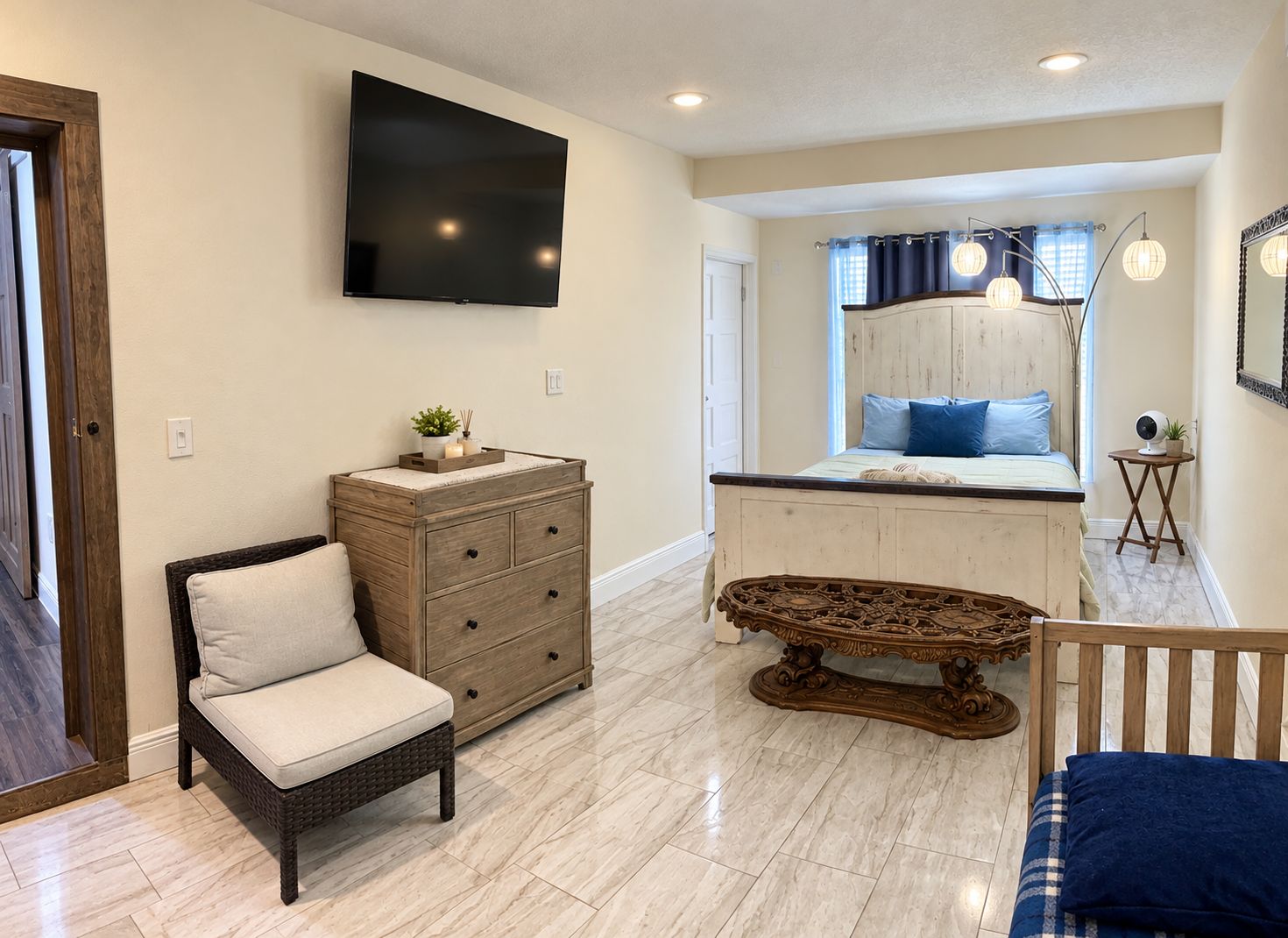 A bedroom with a bed, dresser, television, and a small table.