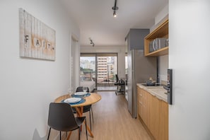 Una cocina moderna con comedor, armarios de madera y vistas a la ciudad.