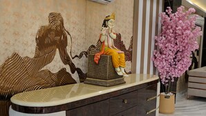 Un comptoir d’accueil orné d’une statue, un appareil de climatisation et une plante en pot.
