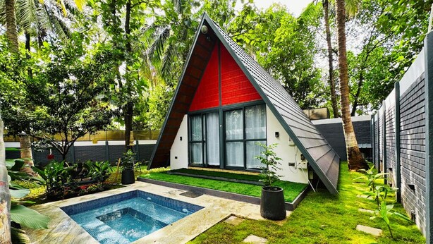 A modern house with a triangular roof, a swimming pool, and lush greenery. - Oh-Bali Villa by Travent Mug (Ramanagara)