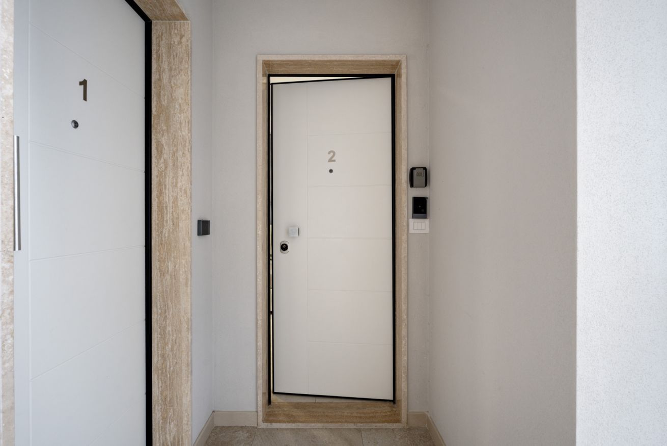 Une porte portant le numéro « 2 », un clavier à code et une petite lumière au-dessus de la porte.